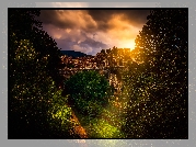 Hiszpania, Miejscowość Besalu, Most Puente de Besalu, Domy, Wzgórza, Drzewa, Roślinność, Wschód słońca, Chmury